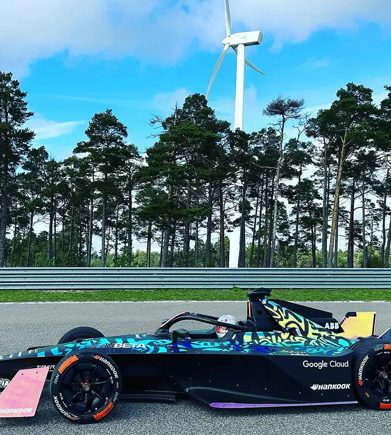 En Formula E-bil och vindkraftverk på Gotland Ring.